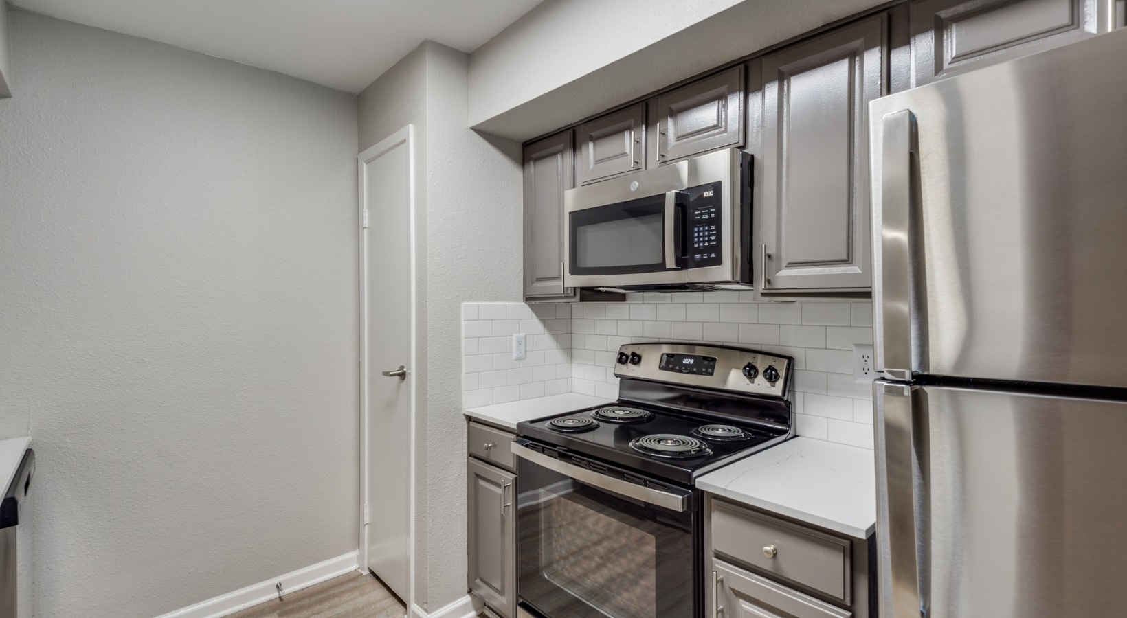 a kitchen with stainless steel appliances and a microwave at The  Sutton
