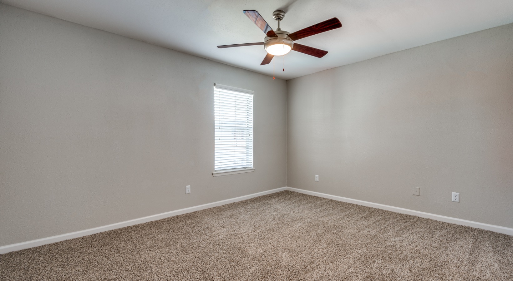 empty room with ceiling fan and carpet at The  Sutton