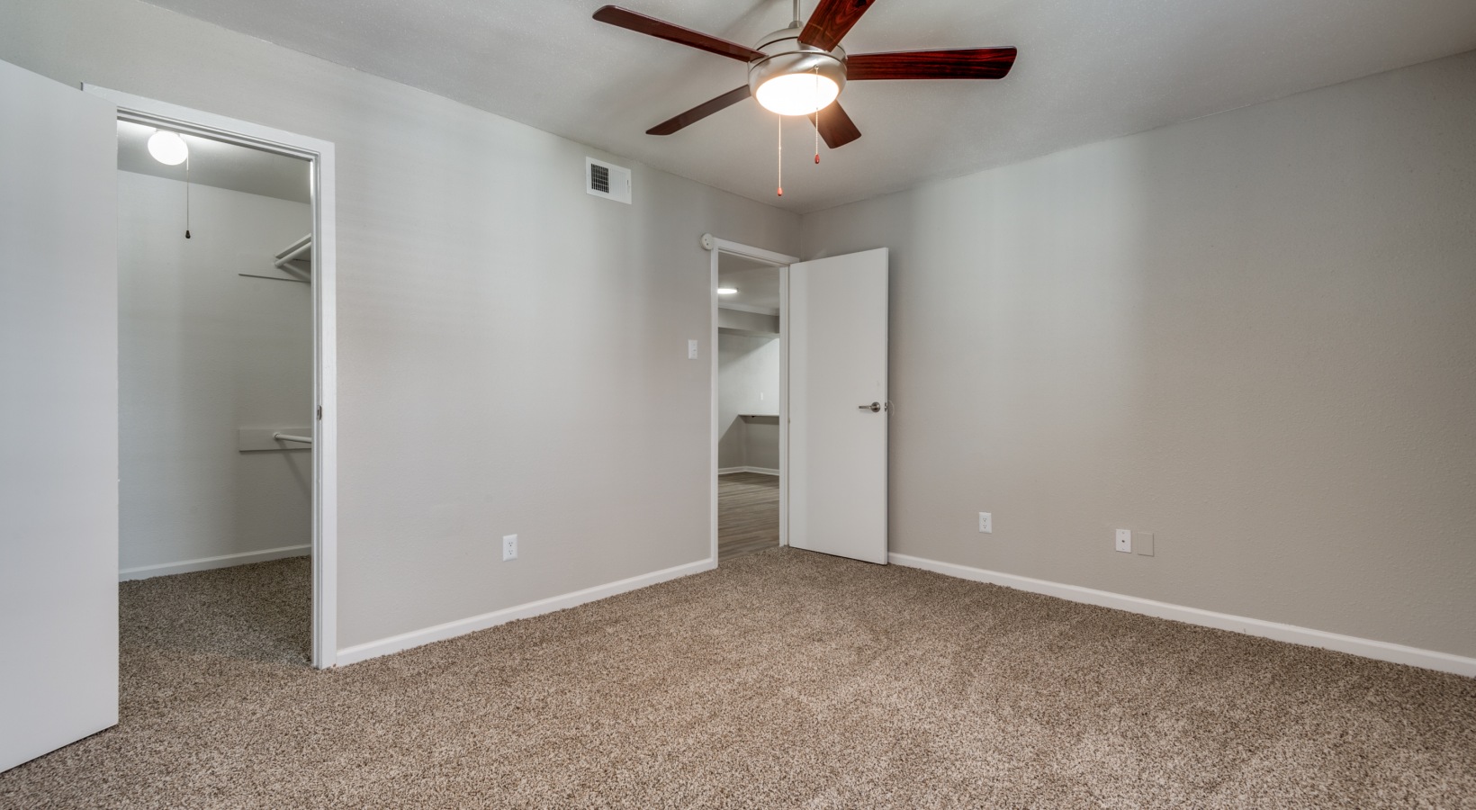 empty room with ceiling fan and carpet at The  Sutton