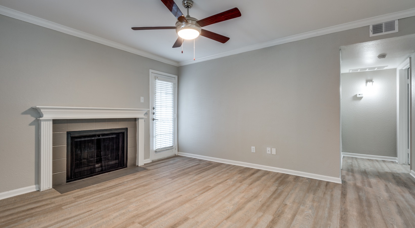 empty living room with ceiling fan and hardwood floors at The  Sutton