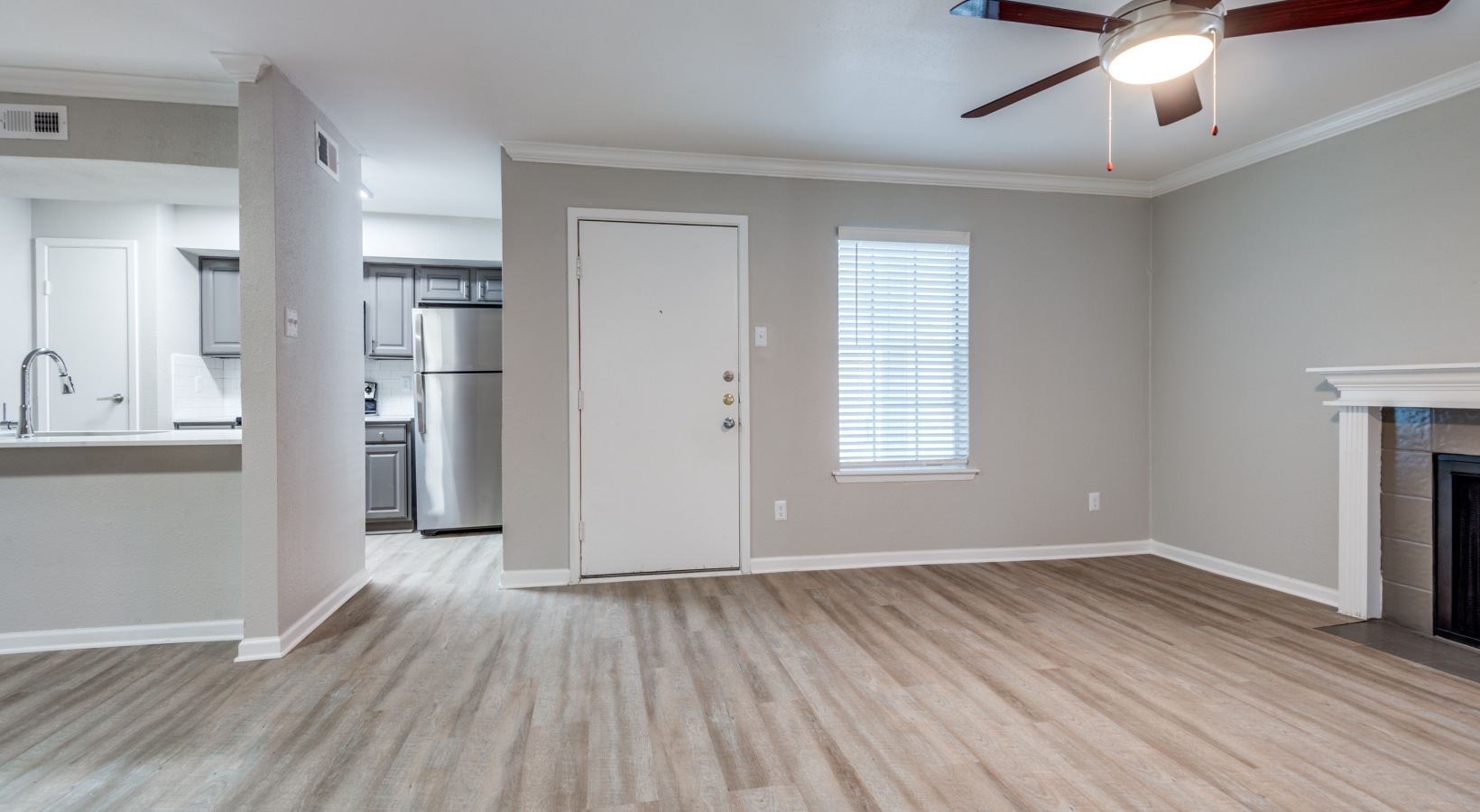 an empty room with hardwood floors and a ceiling fan at The  Sutton