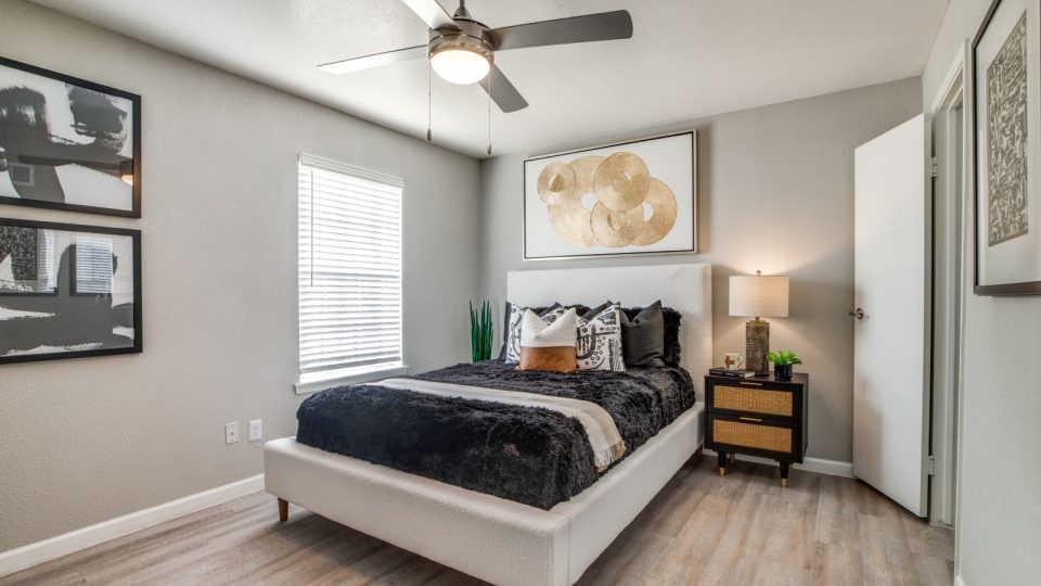 a bedroom with a ceiling fan and hardwood floors at The Sutton