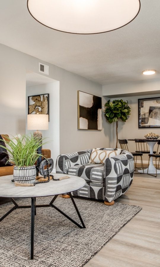 a living room with a couch, coffee table and a painting at The  Sutton