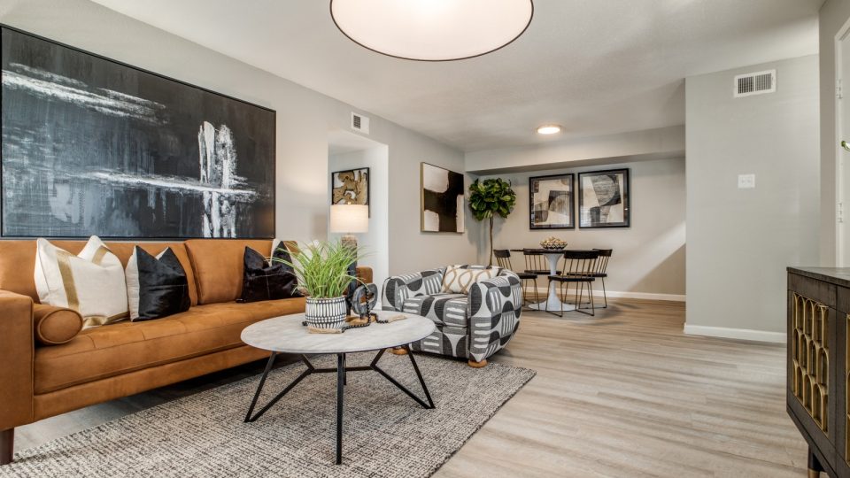 a living room with a couch, coffee table and a painting at The  Sutton