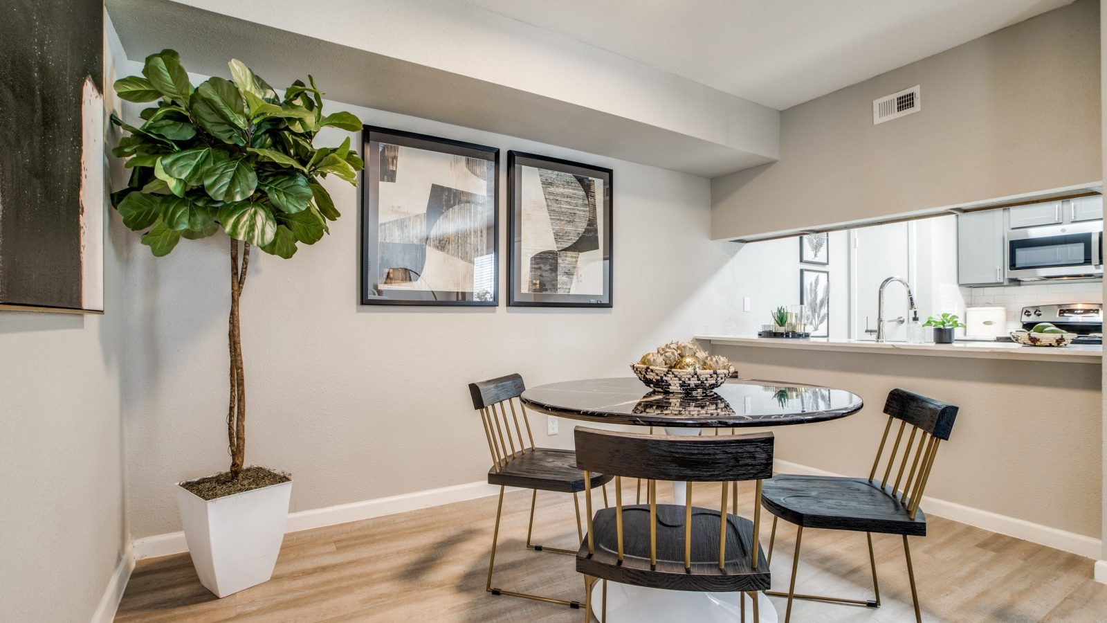 a dining room with a table and chairs and a plant at The  Sutton