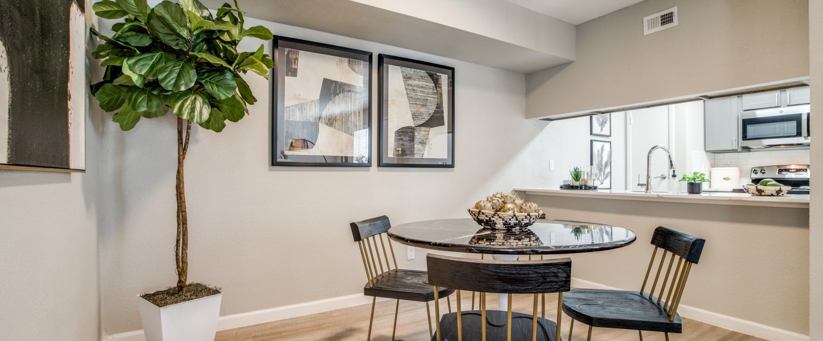 a dining room with a table and chairs and a plant at The  Sutton