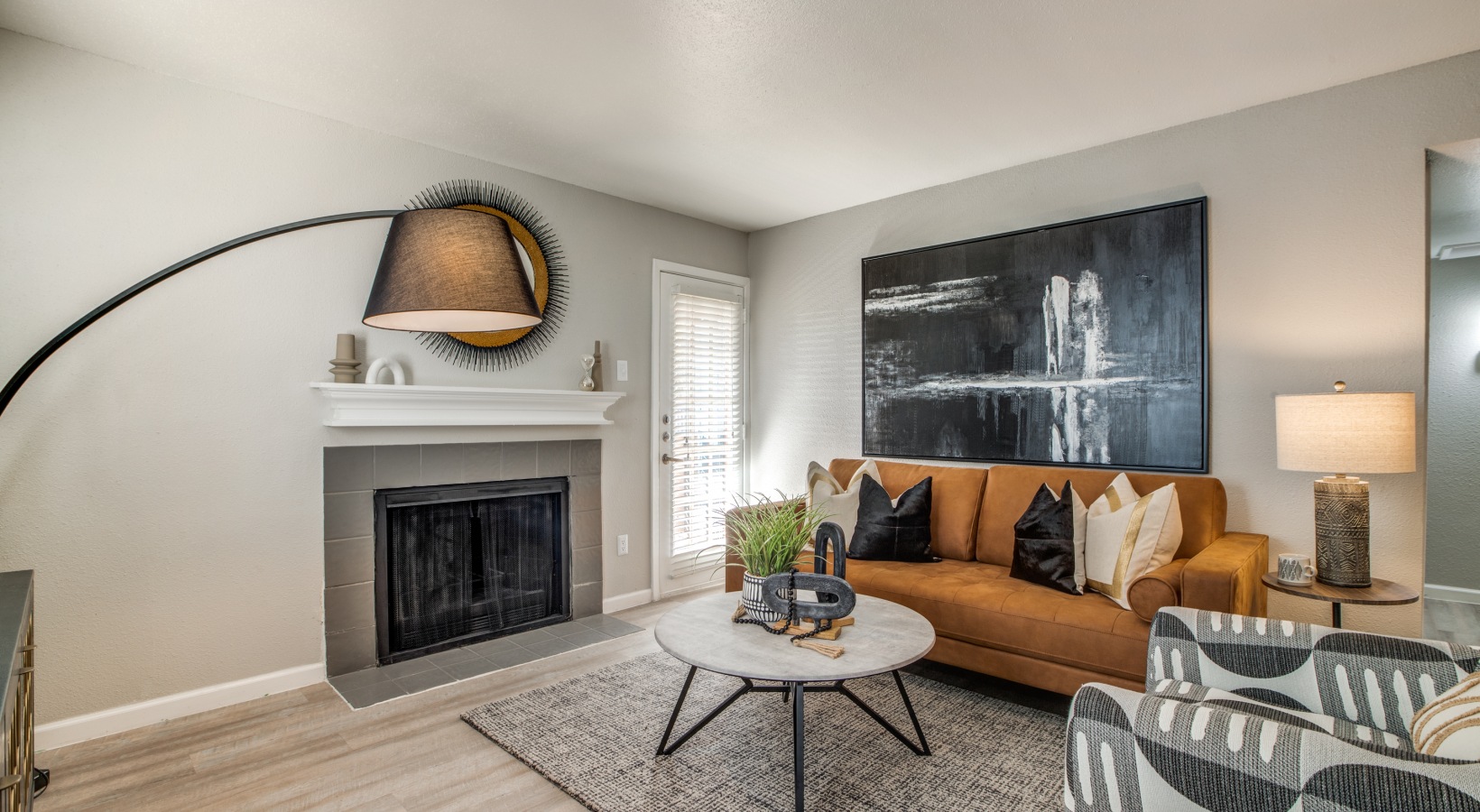a living room with a fireplace and a large painting at The  Sutton