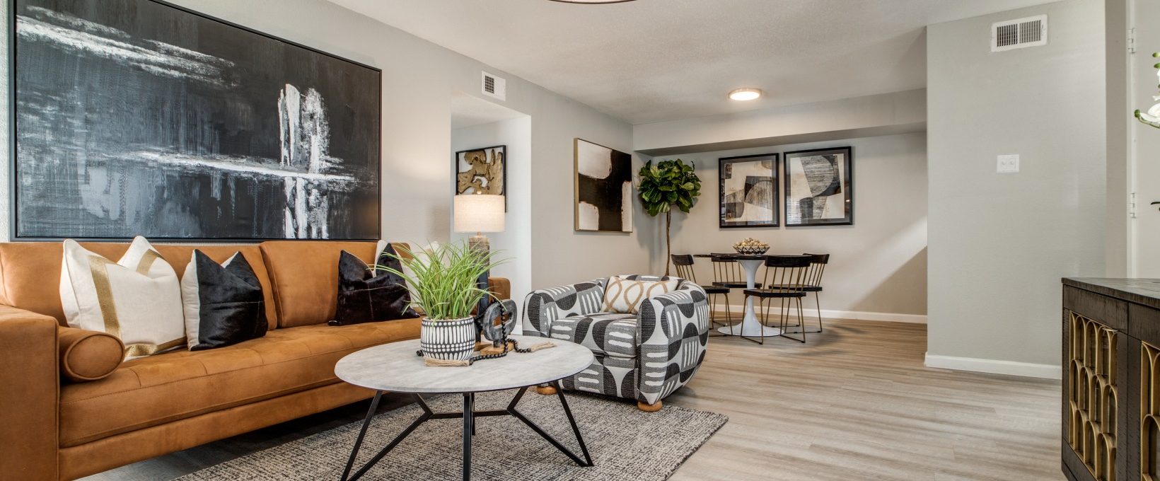 a living room with a couch, coffee table and a painting at The  Sutton